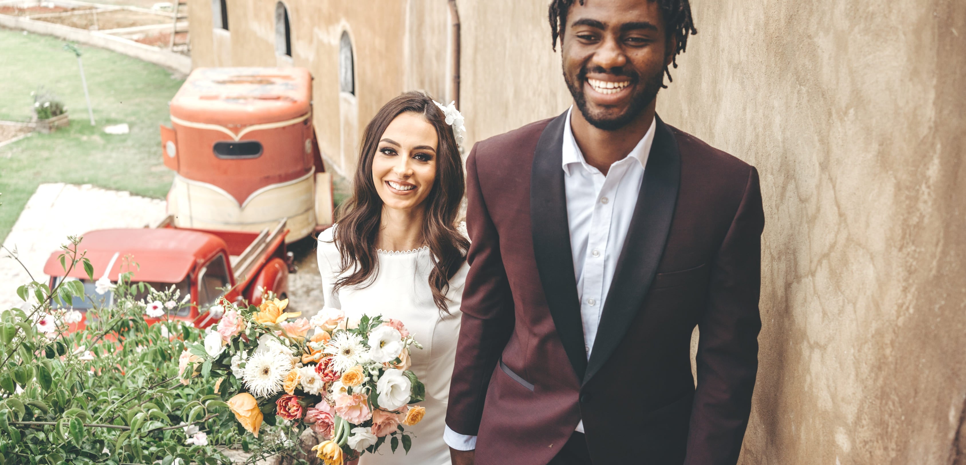 hero-image for weddingpage, a copule smiling with a flowerbouqeut in their hands