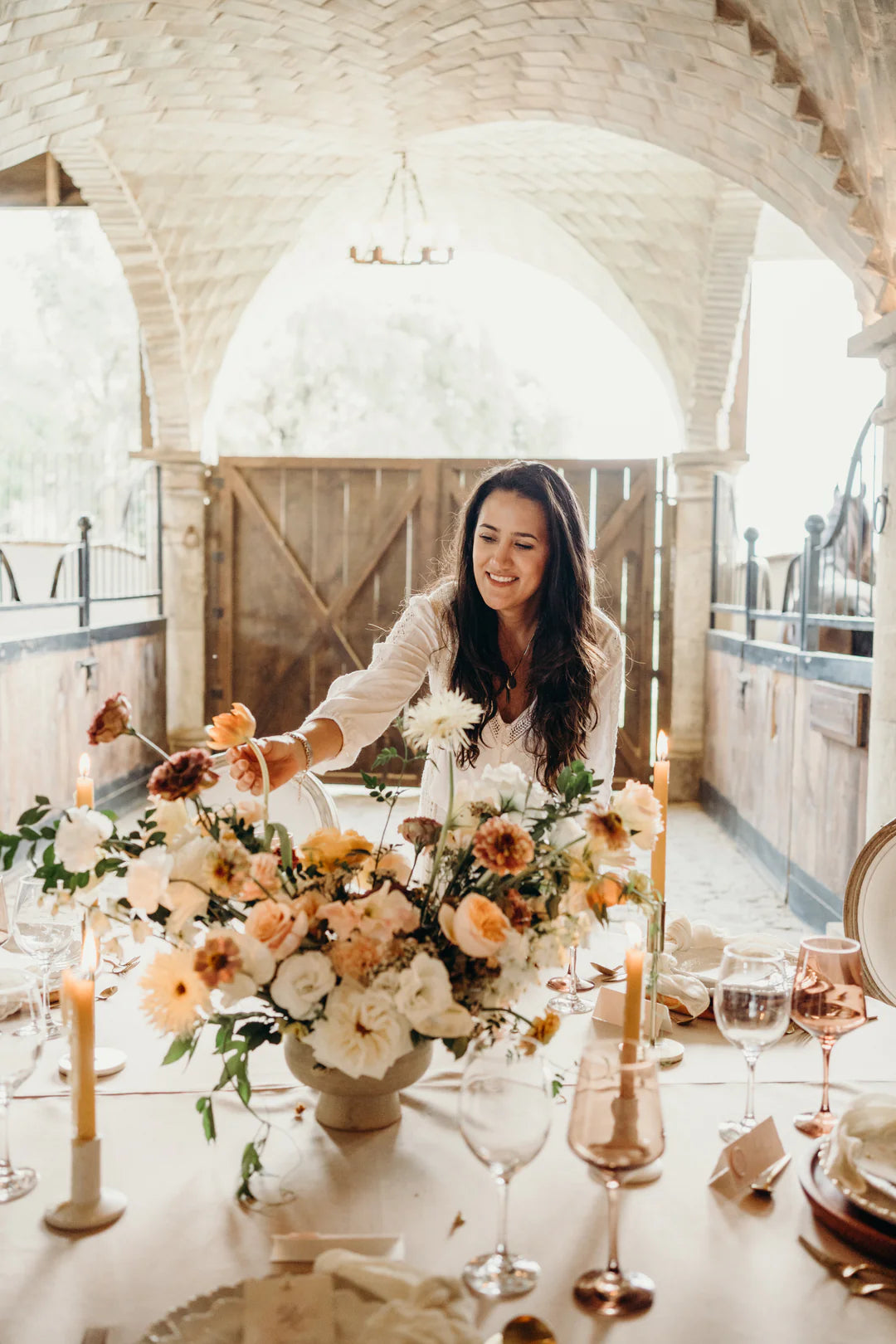 person arranging a flowerbouqet on a table in a nice setting